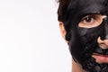 Black mask on man face, well groomed man getting spa treatment. Handsome young guy get Moisturizer rejuvenating black mask on
