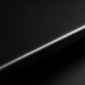 Black matte surface with a slight grainy texture, featuring a curved edge. The close-up Royalty Free Stock Photo