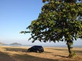 Black Mazda 2 car is parking under big Indian almond tree with sea view at Sapanhin beach