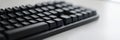 Black mechanical keyboard placed on a smooth desk during a bright work session. Generative AI