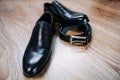 Black men's patent leather shoes for the groom and a leather black belt with an iron buckle Royalty Free Stock Photo