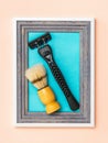 Black men`s razor and shaving brush in a frame on a blue background. Minimalism. Modern creative creativity. Royalty Free Stock Photo