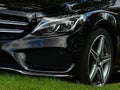 Black Mercedes-Benz AMG sport C-class 220d car, closeup front view of an emblem