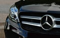 Black Mercedes-Benz AMG sport C-class 220d car, closeup front view of an emblem