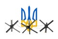 Black Metal Anti Tank Hedgehog Defence Barrage with Barbed Wire in Front of Coat of Arms with Flag of Ukraine, Yellow and Blue