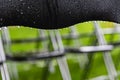 Black metal chairs outside in the park, green grass and water drops. Royalty Free Stock Photo