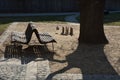 Black metal chairs and round tables in a cafe on a cobbled square with a sand surface of compacted yellow gravel under an old tree Royalty Free Stock Photo