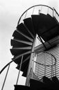 Black metal circular stairs rise towards the sky