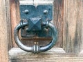 Black metal door knocker, door knob with a ring for knocking on the background of a wooden brown old vintage door Royalty Free Stock Photo