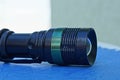 metal flashlight lies on a blue table Royalty Free Stock Photo