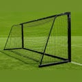 A black, metal-framed soccer goal with a net stands on a well-maintained grass field. Royalty Free Stock Photo