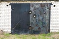 Black metal garage gate with three big locks