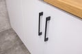 black metal handles on white nightstand cabinets and drawers on kitchen