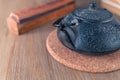 Black metal Japanese tea pot on a wooden table with an old book and wooden box of fragrant sticks. Zen-style still life Royalty Free Stock Photo