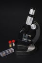 black metal microscope on a dark background. test tubes with a red cap Royalty Free Stock Photo