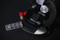 black metal microscope on a dark background. test tubes with a red cap Royalty Free Stock Photo
