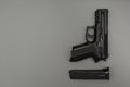 Black metal 9mm pistol and magazine on grey background Royalty Free Stock Photo