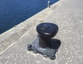 Black metal mooring bollard in marina and port terminal. Close up of mooring noray on a dock. Port conditioning Royalty Free Stock Photo