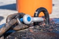 A black metal, rusty industrial chain with a grey key attached to a stone base Royalty Free Stock Photo