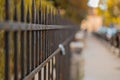 Black metal steel fence in a city. Rustical vintage style fence with spiked tops and rivets visible