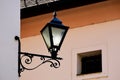 Old wrought iron street light lantern. ornate retro stile lamp. stucco facade. Royalty Free Stock Photo