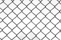 Black metal wire fence with rhombuses in park, view on white sky through it