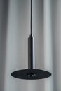 Black metallic lamp hanging on gray curtain background Royalty Free Stock Photo