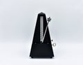 Black metronome isolated on a white background. Royalty Free Stock Photo