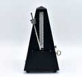 Black metronome isolated on a white background. Royalty Free Stock Photo