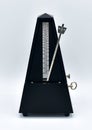 Black metronome isolated on a white background. Royalty Free Stock Photo