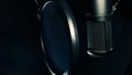Black microphone with pop filter isolated on black background