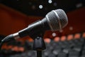 Black microphone setup on a stage in an empty venue. Royalty Free Stock Photo
