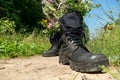 Black military boots with flowers. Concept - flowers instead of bullets and war. Ending the war in Ukraine. The surrender of the Royalty Free Stock Photo