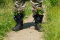 Black military boots with flowers. Concept - flowers instead of bullets and war. Ending the war in Ukraine. The surrender of the Royalty Free Stock Photo