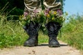 Black military boots with flowers. Concept - flowers instead of bullets and war. Ending the war in Ukraine. The surrender of the Royalty Free Stock Photo