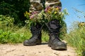 Black military boots with flowers. Concept - flowers instead of bullets and war. Ending the war in Ukraine. The surrender of the Royalty Free Stock Photo