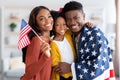 Black military man wrapped in flag posing with wife and little daughter Royalty Free Stock Photo