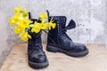 Black military muddy shoes with yellow narcissus