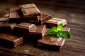 Black and milk chocolate bars with mint dark wooden table background