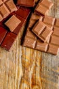 Black and milk chocolate pieces wooden table background top view mock up Royalty Free Stock Photo