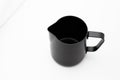 Black milk stainless pitcher object make coffee on white table and fabric background Royalty Free Stock Photo