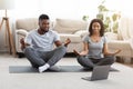 Black Millennial Couple Practicing Yoga Online With Instructor On Laptop