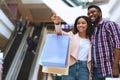 Black Millennial Couple Shopping Together In Mall, Young Woman Pointing At Showcase Royalty Free Stock Photo