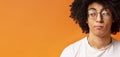 Black millennial man looking skeptically aside at empty space Royalty Free Stock Photo