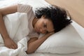 Black millennial woman lying in bed suffering from insomnia