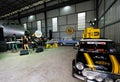 Black Mini Austin classic car with yellow box on roof parking in a garage