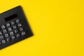 Black minimal calculator on solid yellow background with copy space using for financial activity, accounting, tax calculation or Royalty Free Stock Photo