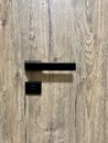 Black minimalist modern handle on dark wooden door. Close-up photo. Concept of living, furniture, furnishing a new Royalty Free Stock Photo