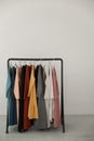 Black minimalistic rack with eco linen clothes on white background.