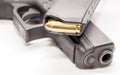 A black 9mm pistol with a pistol magazine loaded with full metal jacket bullets on top of it Royalty Free Stock Photo